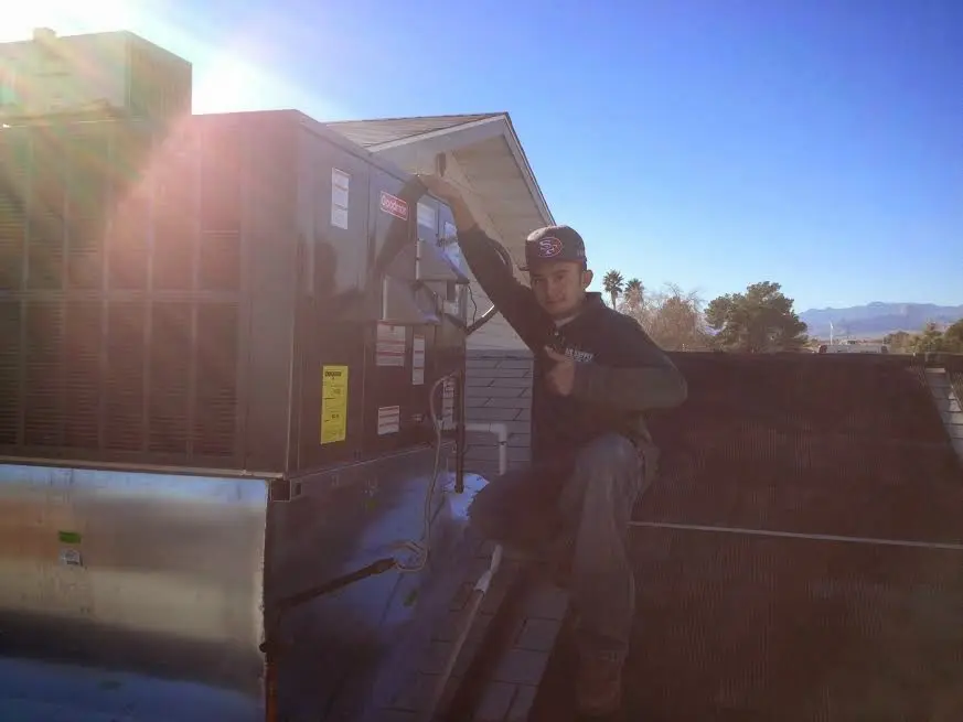 HVAC technician performing Air Duct Cleaning on a rooftop unit in Hickory Hills